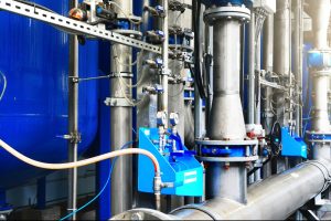Large industrial water treatment and boiler room. Shiny steel metal pipes, blue pumps, valves. Industry, technology, special equipment, biotechnology, chemistry, ecology, heating. Panoramic image