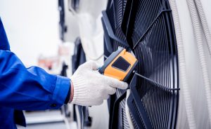 Technician uses a thermal imaging infrared thermometer to check the condensing unit heat exchanger