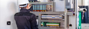 Man worker checking advanced industrial control panel; note shallow depth of field