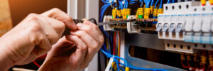 The man is repairing the switchboard voltage with automatic switches. Electrical background